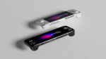 Two AYANEO Pocket S2 handheld gaming consoles, one white and one black, are laid flat and parallel on a light grey surface. The white console is positioned above and slightly to the right of the black console. Both screens display "AYANEO Pocket S2" with vibrant abstract backgrounds. The white console shows its D-pad and left analog stick, while the black console shows its face buttons and right analog stick.