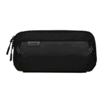 A horizontal, black carrying case for a handheld gaming device is shown against a plain grey background. The case has a textured top half and a smooth, matte bottom half. A small, dark grey patch with "AYANEO" in white text is stitched onto the front. The case has two zippers and two diagonal reflective stripes on either side of the front panel.
